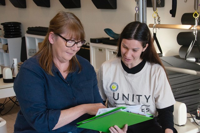 Danielle King of Green Moves with Elisa Messina, owner of Unity Pilates in discussion during an energy assessment.