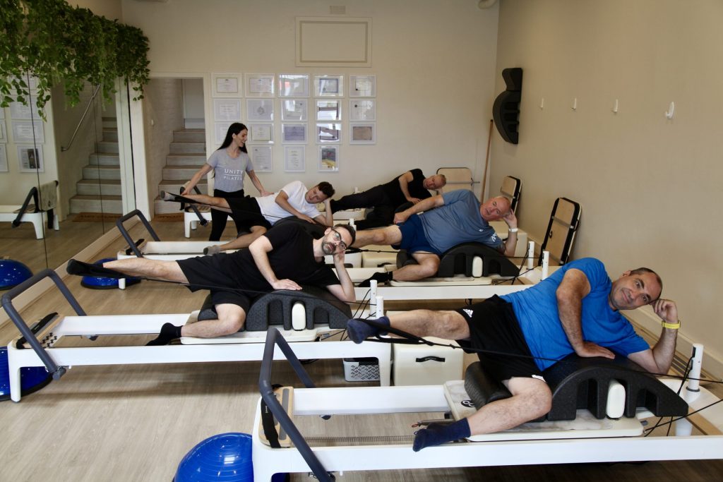 Men on Reformer Pilates equipment at Unity Pilates in East Brighton.