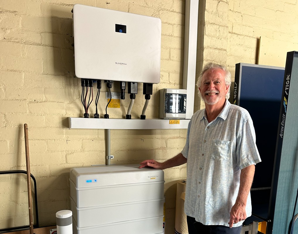Parkdale homeowner Michael pictured at home by their solar inverter and battery