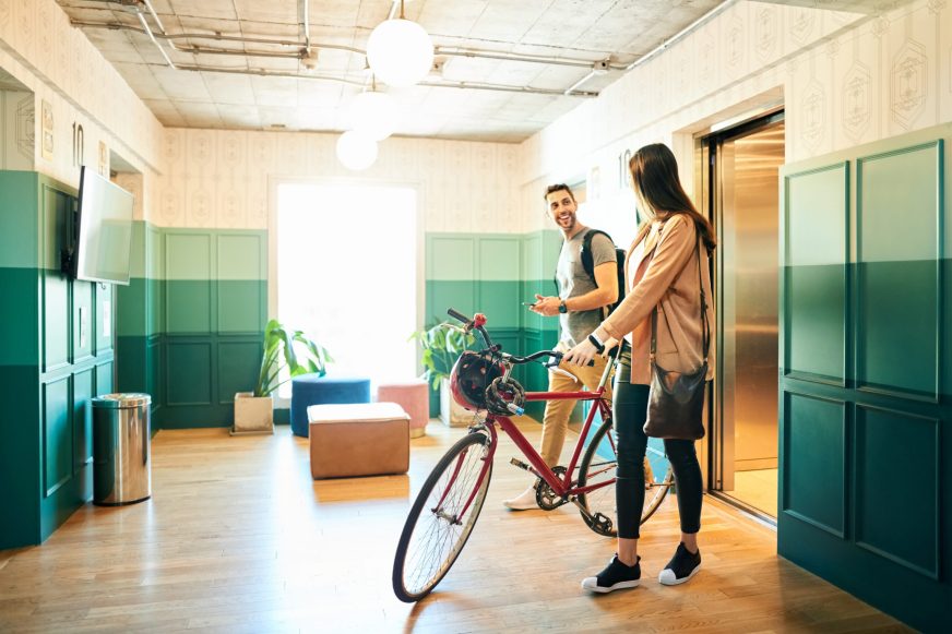 Young coworkers arriving in office with bicycle