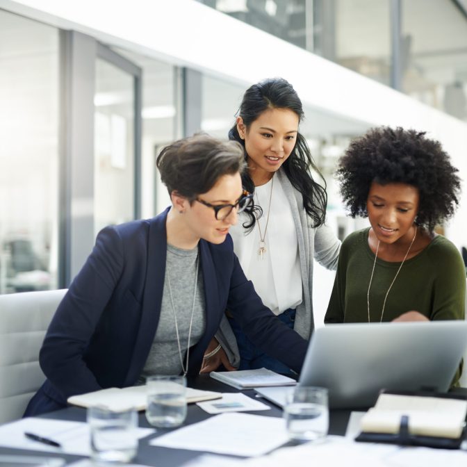 Shot of a group of businesswomen using a laptop during a meeting at work